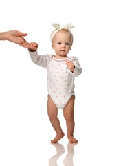 Small infant child baby girl toddler make first steps with mother hand help