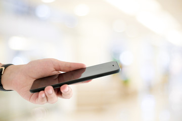 Hand using smart phone over blur bokeh light background, business and technology, internet of things concept