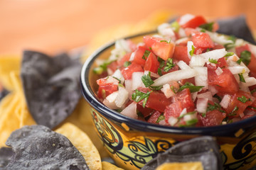 Pico De Gallow in a traditional ceramic bowl with blue corn and white corn tortilla chips