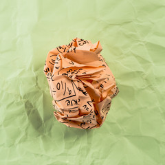 Crumpled multi colored paper balls with mathematical equations on multi colored plain paper, with...