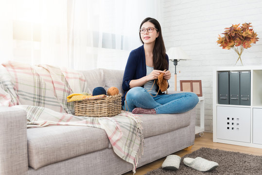 woman sitting on sofa looking outside