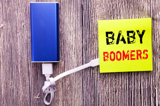 Handwriting Announcement text showing Baby Boomers. Business concept for Demographic Generation written on sticky note with copy space on old wood wooden background with power bank