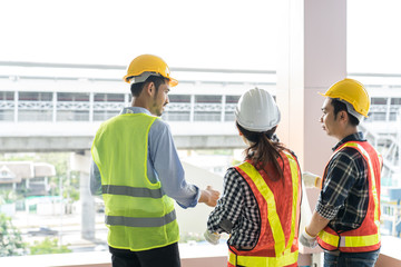 engineers visit the construction site.Examining blueprint with construction manager.