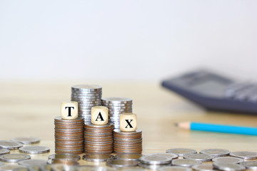 Tax Concept, Wooden block on Stacking coins money on white background