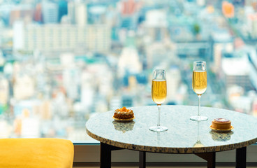 Gourmet pastries with white wine in a room high above the city