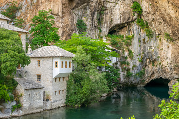 Fototapeta na wymiar A clean underground river emerges from a cave near an Islamic mosque.