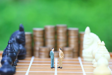Leadership for success game, Miniature businessman standing on chessboard and chess background, Strategy investment and business concept
