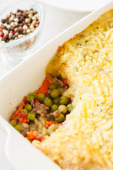 Shepherds pie -  Irish traditional food. Served in a ceramic dish on a white stone background.