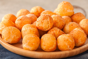 Small cottage cheese doughnuts (castgnole) on a wwoden plate.