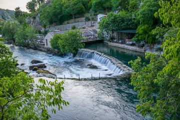 Fototapeta na wymiar The mountain river formed a small waterfall among the stony rapids.
