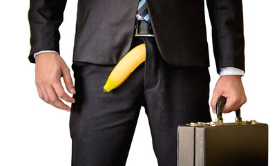 Business man with banana sticking out of his trousers like a man having a problem with his penis...