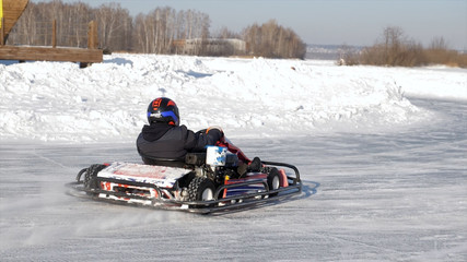 Fototapeta na wymiar Winter karting competition on the ice track. Winter carting. Racing karting in slow motion