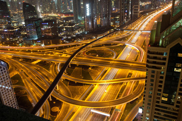 Fototapeta na wymiar DUBAI, UAE - FEBRUARY 2018: Night traffic on a busy intersection on Sheikh Zayed highway