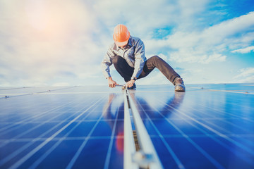 Fototapeta na wymiar Electrical and instrument technician use wrench to maintenance electric system at solar panel field