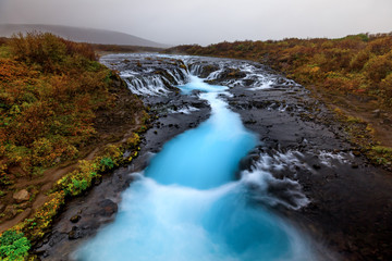 Bruarfoss, Iceland wide angle with it's dramatic and brilliant blue glacier water with fall colors lining the shores