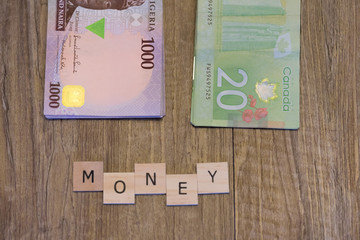 Nigerian Naira and Canadian Dollars with Money spelled out in letter tiles