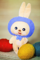 Easter bunnytoy with color eggs in the straw background