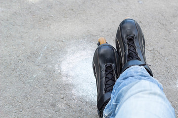 Sport skating in park. Guy putting on roller skates. Man in outdoor fitness activities