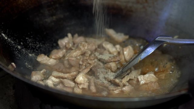 Cooking fried pork with garlic in pan , Thai traditional food
