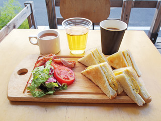  Omelette sandwich with tomatoes,salad and bacon on wooden board    