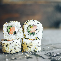 Japanese sushi roll philadelphia on black stone. Selective focus. Blurred foreground and background. Concrete grey background