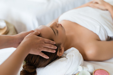 Obraz na płótnie Canvas Beautiful Asian girl relaxing receiving facial massage in a spa salon