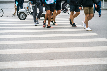 People walking across a street in Hanoi, Vietnam. Closeup