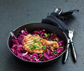 Pork cutlet on a bone with a salad of red cabbage.