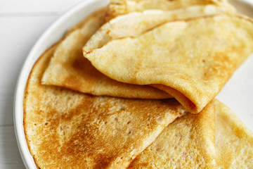 Macro shot of pancakes stacked in white plate