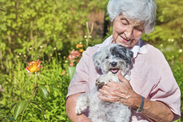 Beautiful Senior Woman Hugging her Cute Havanese Dog Outdoor