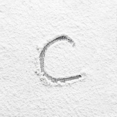 Letter C written on flour