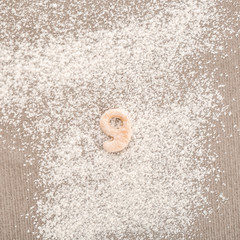 Fototapeta na wymiar Figure NINE made of raw dough on flour