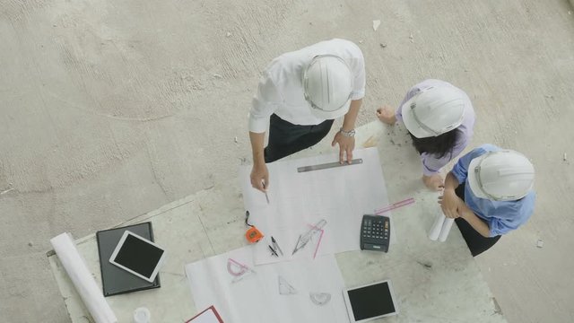 Top view of architect and engineer brainstorming at a construction site.