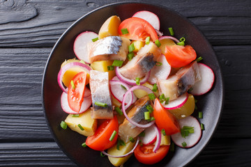 Salad of vegetables with smoked mackerel close-up on a plate. Horizontal top view