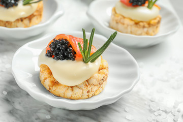 Tasty appetizer with black caviar and salmon on plate
