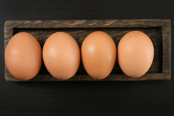 Holder with chicken eggs on table