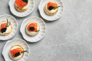 Tasty appetizer with black caviar and salmon on plates