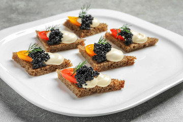 Tasty black caviar appetizer on plate