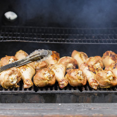 Appetizing turkey drumsticks on the grill, on charcoal stove with fire and smoke close-up . Concept summer picnic, nutrition, diet