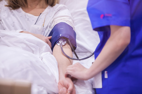Infirmi&egrave;re qui prend la pression &agrave; une patiente malade