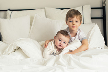 Fototapeta na wymiar Two little pretty thoughtful brothers in bed