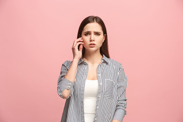 Let me think. Doubtful pensive woman with thoughtful expression making choice against pink background