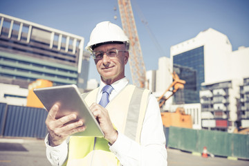 Construction manager controlling building site and tablet device
