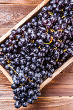 Photo of black grapes in wooden box