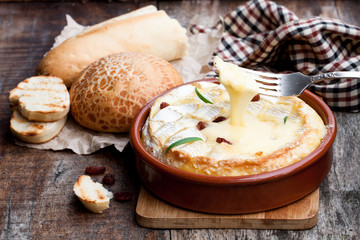 Delicious  hot baked camembert with sultanas on wooden table - obrazy, fototapety, plakaty