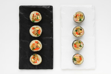 Korean dried Seaweed Rolls, gimbap. Made with carrot, eggs, kim, rice, salt, sesame oil, vinegar, sesame seeds, yellow radish, carrots, ham, spinach, fish cakes, burdock, eggs, rice, crab meat.