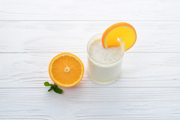 Smoothies with bananas and oranges, a sprig of mint on a white background. Space for text or design.
