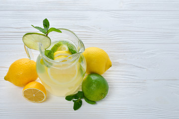Citrus lemonade and lime water with lemon sliced , healthy and detox water drink in summer on white wooden table