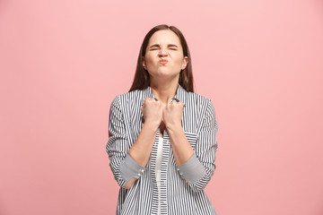 Obraz premium Portrait of an angry woman looking at camera isolated on a pink background