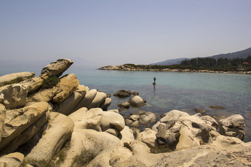 Man standing alone on beach. Vourvourou, Sithonia, Chalkidiki, Greece.